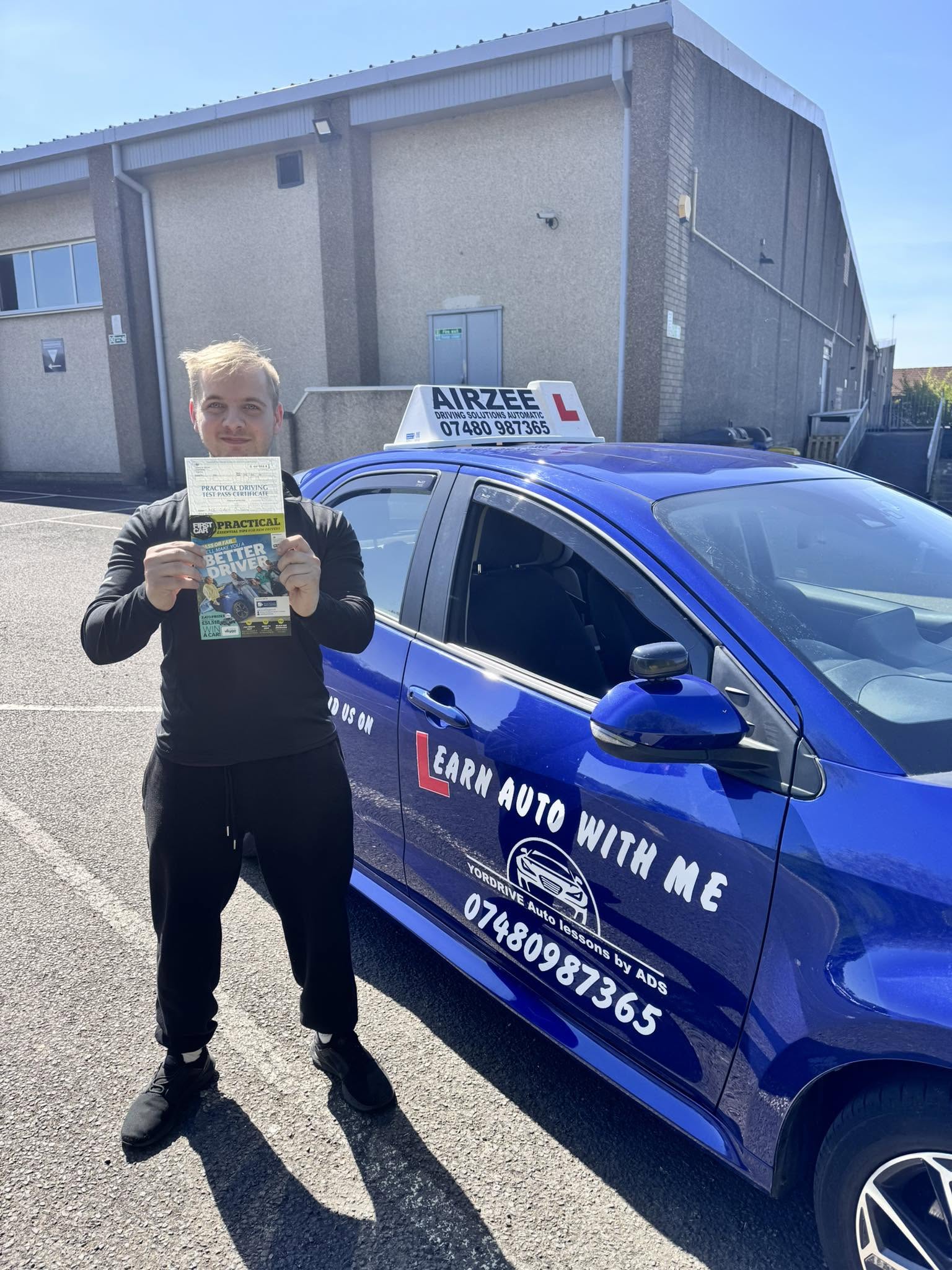 YorDrive learner celebrating with practical driving test pass certificate, blue training car