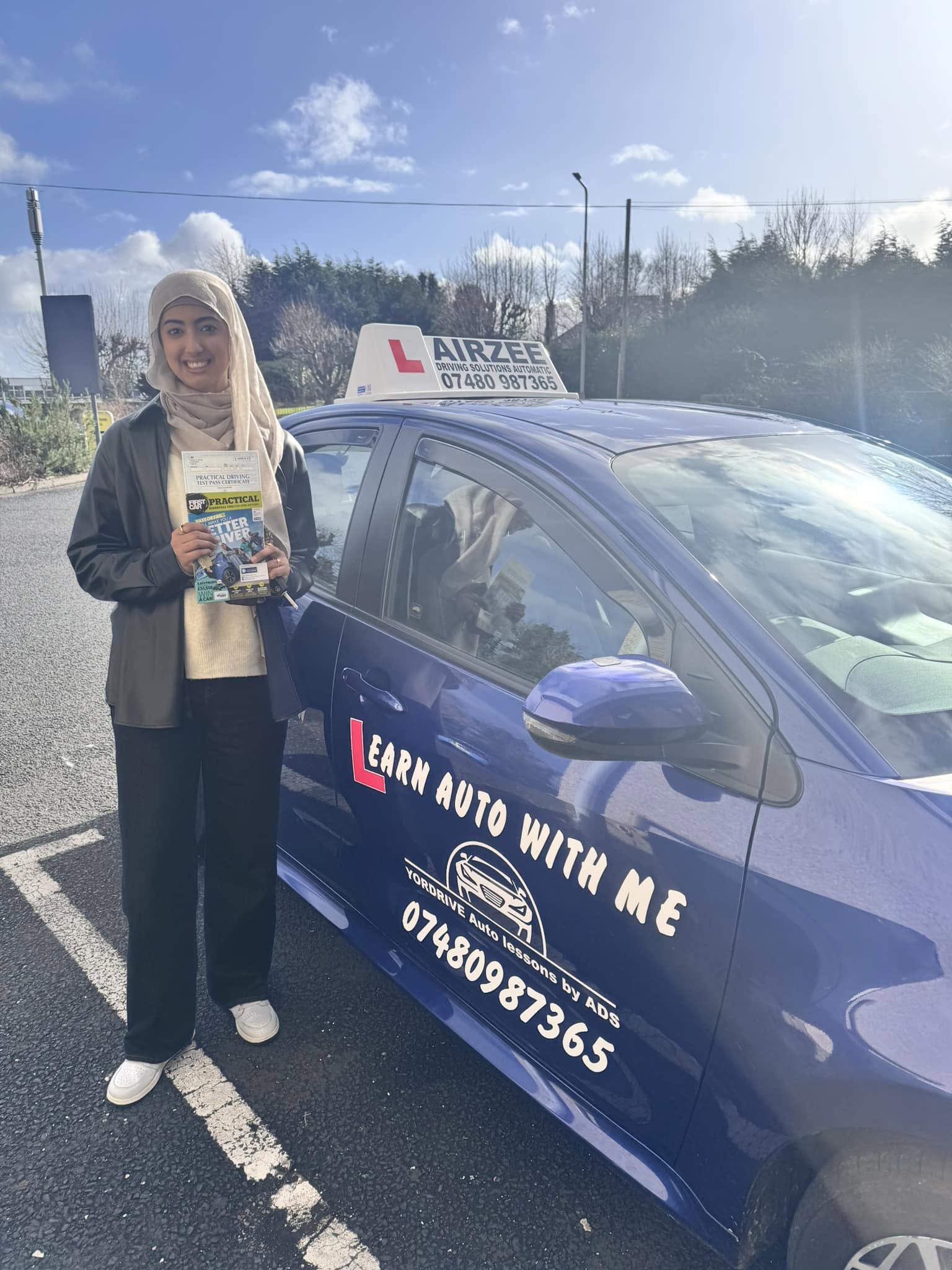 YorDrive learner celebrating with practical driving test pass certificate, blue training car